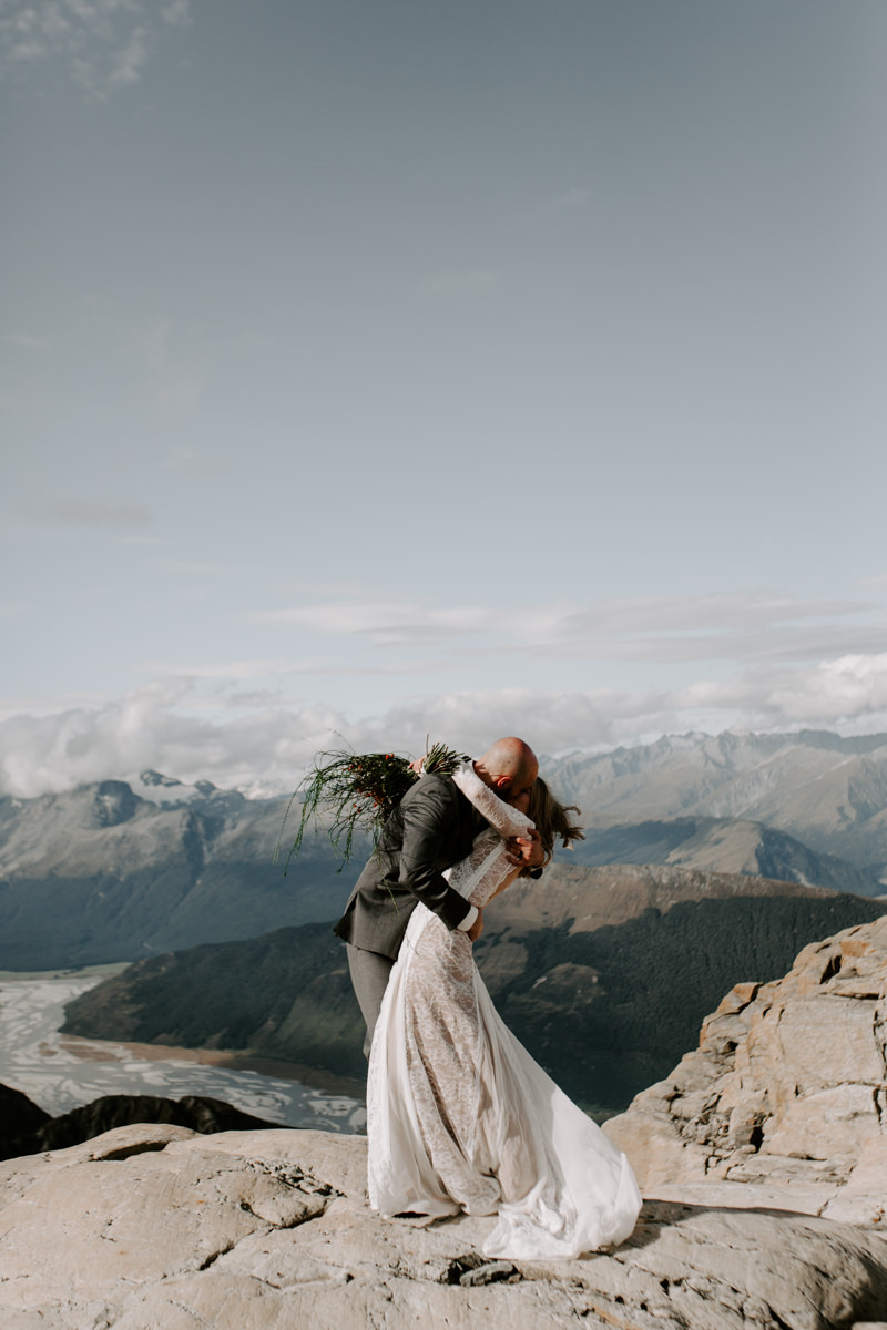 Bride with groom standing on a mountain at Glenorchy wedding by Dawn Thomson Photography